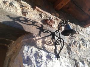 une cloche suspendue sur le côté d'un mur en pierre dans l'établissement Casa Rita, à Morella