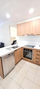 a kitchen with a stove, sink and refrigerator at Ramada by Wyndham Brisbane Windsor in Brisbane