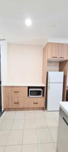 a kitchen with a stove, microwave and refrigerator at Ramada by Wyndham Brisbane Windsor in Brisbane