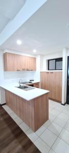 a kitchen with a sink, stove, and refrigerator at Ramada by Wyndham Brisbane Windsor in Brisbane