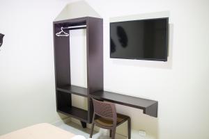 einen TV-Schrank mit einem Stuhl und einem TV in der Unterkunft Hotel San Martin in Tarapoto
