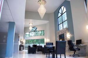 a lobby with a table and chairs and a chandelier at Motel 6-Suwanee, GA - Gwinnett Center in Suwanee