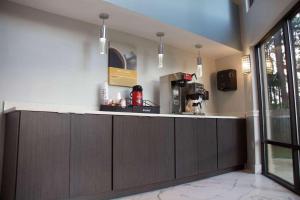 a kitchen with wooden cabinets and a counter top at Motel 6-Suwanee, GA - Gwinnett Center in Suwanee
