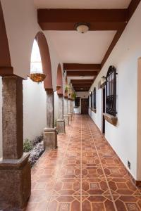 a hallway of a building with a tile floor and an arcade at APARTAMENTOS CASCO HISTORICO COMAYAGUA in Comayagua
