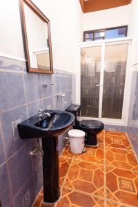 baño con lavabo negro y aseo en APARTAMENTOS CASCO HISTORICO COMAYAGUA en Comayagua