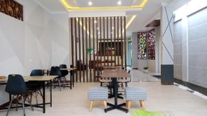 a restaurant with tables and chairs in a room at Alzara Hotel Syariah in Wonosari