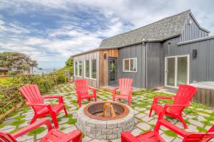 un patio con sillas rojas y una hoguera en Holiday Beach House, en South Beach