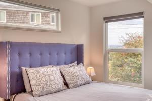 1 cama con cabecero azul junto a una ventana en Holiday Beach House, en South Beach