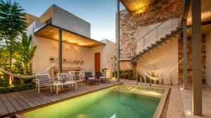 a house with a swimming pool and a patio at Villa Orquídea Boutique Hotel in Mérida