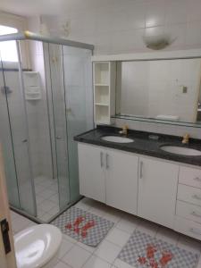 a bathroom with two sinks and a shower and a toilet at Ap por temporada com 2 quartos e uma suíte , excelente área de lazer, Praia do Futuro, condomínio Cartier-Fortaleza in Fortaleza