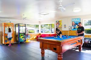 a group of people playing pool in a room with a pool table at Main Beach Tourist Park in Gold Coast