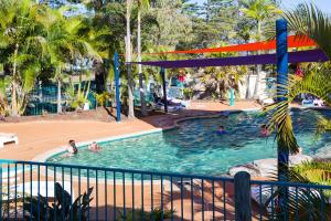 una piscina en un complejo con gente en el agua en Main Beach Tourist Park en Gold Coast