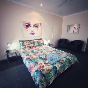 a bedroom with a bed with a colorful bedspread at Wentworth Central Motor Inn in Wentworth