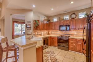 a kitchen with wooden cabinets and a sink and a stove at Peaceful in the Parks in Bend