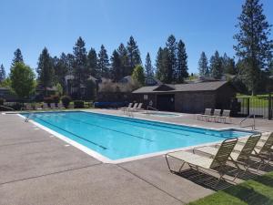 a large swimming pool with chairs and a house at Peaceful in the Parks in Bend