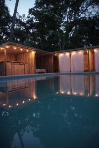 a swimming pool in front of a house with lights at Boatique Hotel and Marina in Río Dulce
