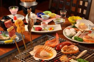 a wooden table with plates of food on it at Sapporo's Secret Onsen Sanctuary Marukoma Onsen Ryokan in Chitose