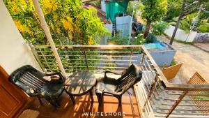 two chairs and a table on a balcony at White Shore Beach Homestay in Alleppey