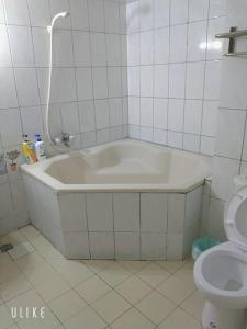 溫泉村的住宿－知本溫泉禾平的家 ，带白色浴缸的浴室和卫生间