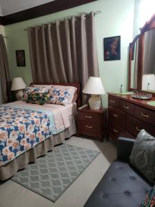 a bedroom with a bed and a dresser at Irie HideAway - Private Studio in Gated Community --Caribbean Estates, Portmore in Goshen Pen
