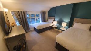 pokój hotelowy z 2 łóżkami i oknem w obiekcie Beautiful House And Elevated Garden In Bridgnorth w mieście Bridgnorth