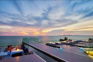 a view of the ocean from a deck at sunset at Veranda Pattaya Luxury Design Balcony with seaview in Na Jomtien