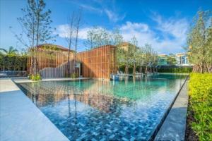 a swimming pool with blue water in a yard at Veranda Pattaya Luxury Design Balcony with seaview in Na Jomtien