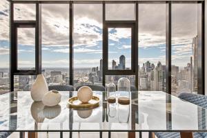 a dining room with a view of the city at Melbourne City Apartments Panoramic Sky View Penthouse in Melbourne
