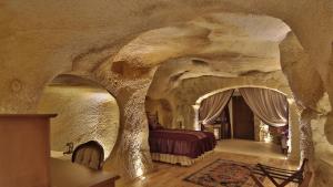 a large room with a bed in a cave at Golden Cave Suites in Ürgüp