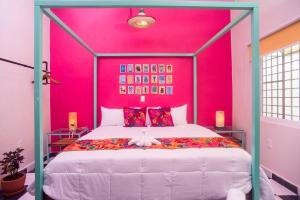 sypialnia z dużym łóżkiem i różową ścianą w obiekcie CASA MARÍA MALECÓN w mieście Puerto Vallarta