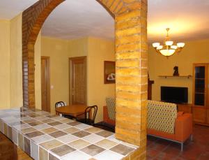 a living room with a tile floor and an archway at La Villa Don Quijote in Cuenca