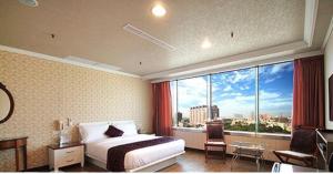 Ya Tai Hotel في Liugui: غرفة فندقية بسرير ونافذة كبيرة