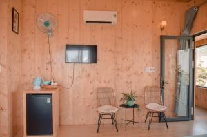 um quarto com duas cadeiras e uma televisão na parede em Little Home Homestay em Con Dao