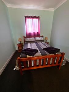 
a bedroom with a bed and a dresser at Manuka Cottage in Broken Hill
