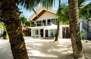 a building with palm trees in front of it at Mabuhay Beach House in Boracay