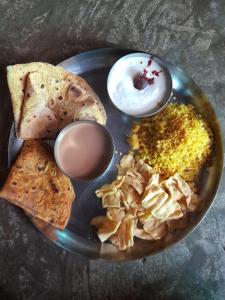 a plate of food with eggs and bread and dips at The Wilds Villa Gir Jungle Stay with Swimming Pool in Sasan Gir
