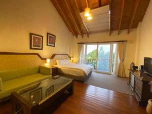 a bedroom with a bed and a couch and a television at Ailiga Travel Villa in Renai +47 photos