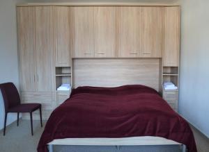 - une chambre avec un lit doté d'armoires en bois et d'une chaise dans l'établissement Bisang S, à Arosa