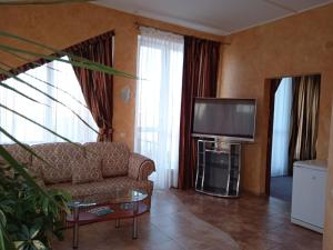 sala de estar con sofá y TV de pantalla plana en Hotel Mys, en Sevastopol