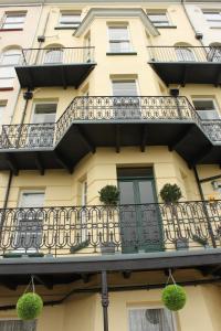 a building with a balcony with potted plants on it at The Collingdale Guest House in Ilfracombe