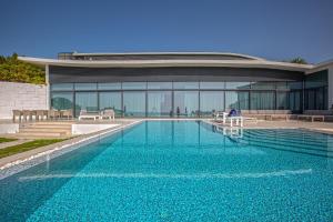 a large swimming pool in front of a building at Paradise Nurai Villa - 6 Bedrooms in Abu Dhabi