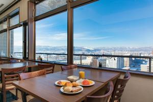 una mesa con platos de comida y vistas a la ciudad en Premier Hotel -CABIN- Asahikawa, en Asahikawa