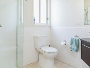 bagno bianco con servizi igienici e finestra di Riptide at Cape Woolamai a Cape Woolamai Altre 13 foto