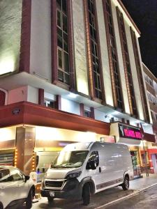 una furgoneta blanca estacionada frente a un edificio en Yilmazel Hotel, en Gaziantep