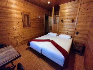a bedroom with a bed in a wooden room at B&B La Seigneurie in Les Gets