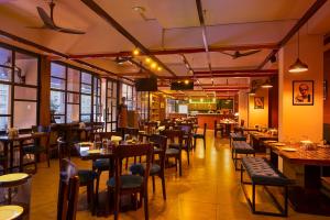 a restaurant with tables and chairs in a room at Hometown Galleria Manipal in Manipala