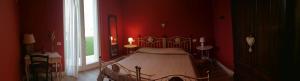 sypialnia z łóżkiem z czerwonymi ścianami i oknem w obiekcie B&B Solstizio d'estate w mieście San Felice del Benaco