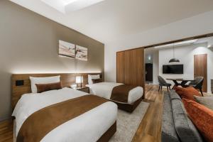 a hotel room with two beds and a couch at The Vale Rusutsu in Rusutsu