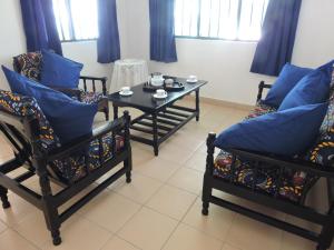 a living room with two chairs and a table at Diani Beachalets in Diani Beach