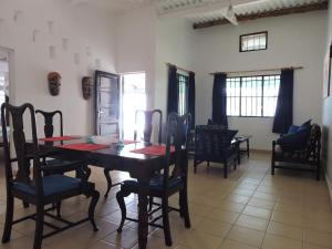 a dining room with a wooden table and chairs at Diani Beachalets in Diani Beach